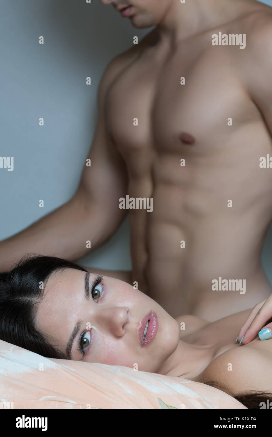 A happy girl after having sex. The girl dreams of sex. Pleasure of young people. Sex of the young. Male body in the background Stock Photo
