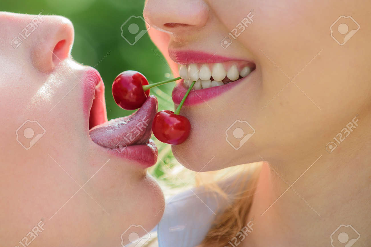 Lesbian Story. Cherries In The Female Mouth Concept. Passion And Love. Homosexual Couple. Delicious Food Date. Erotica Lgbt. Female Sensual Tongue And Lips. Lick Cherry. Two Beautiful Women Close Up. Stock Photo