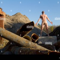 Male nude form stood amongst construction material Stock Photo